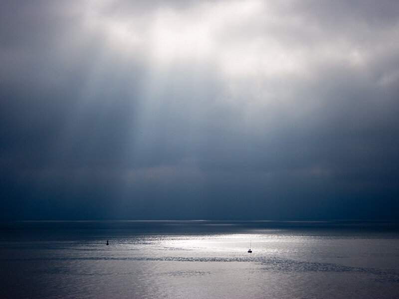 Sailboat in Stormy Sea — Gray, Dramatic, Photograph, Clouds, Sunbeams