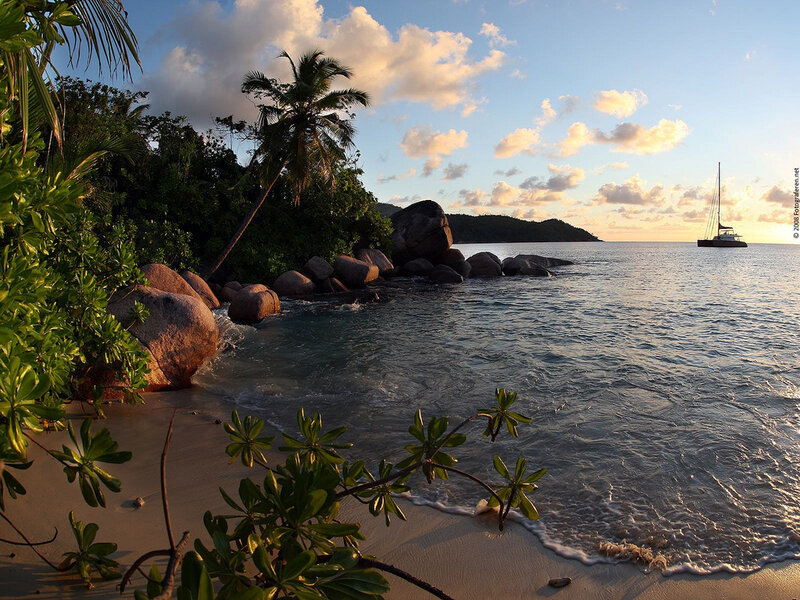Sailboat in Tropical Bay — Blue, Serene, Sunset