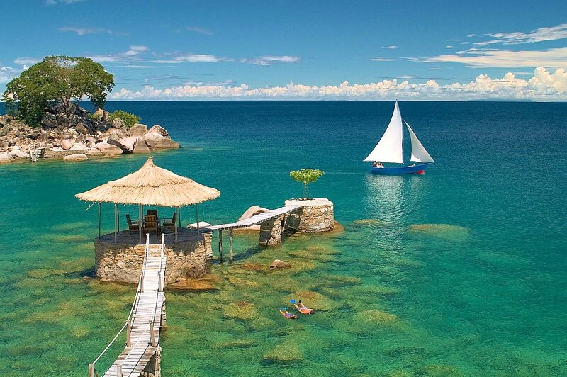 Sailboat in Turquoise Water — Blue, Serene, Afternoon, Photograph, Thatched Hut, Dock