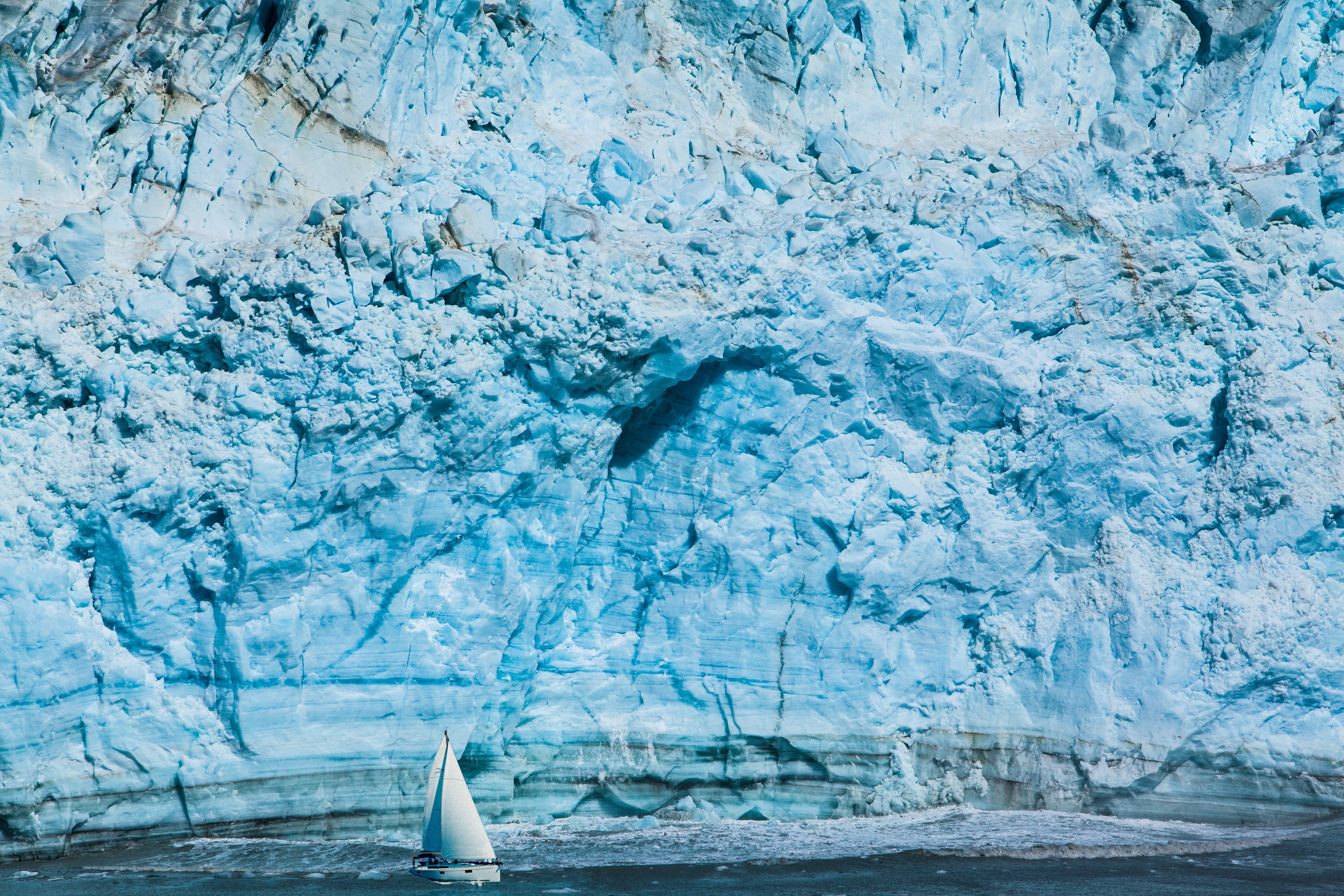 Sailboat near glacier wall