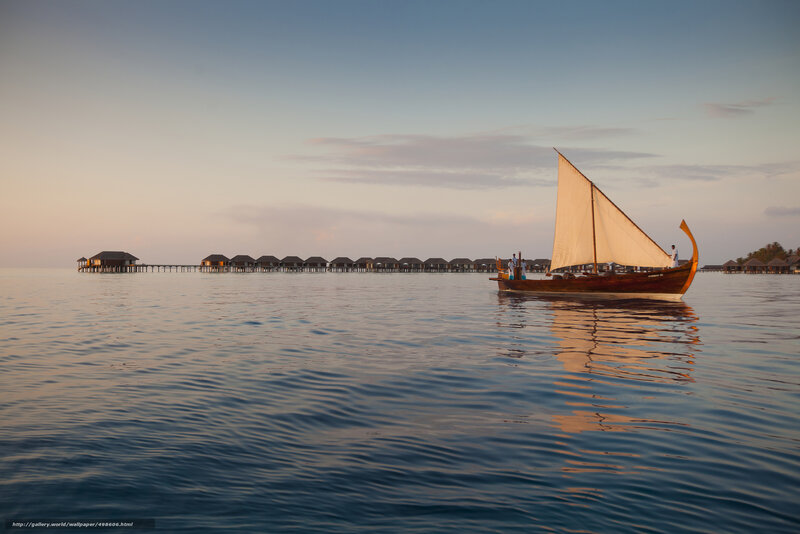 Sailboat near overwater bungalows