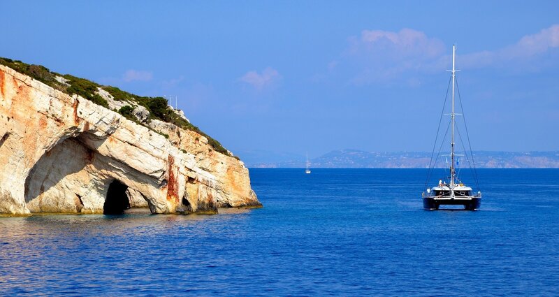 Sailboat near rocky coastline