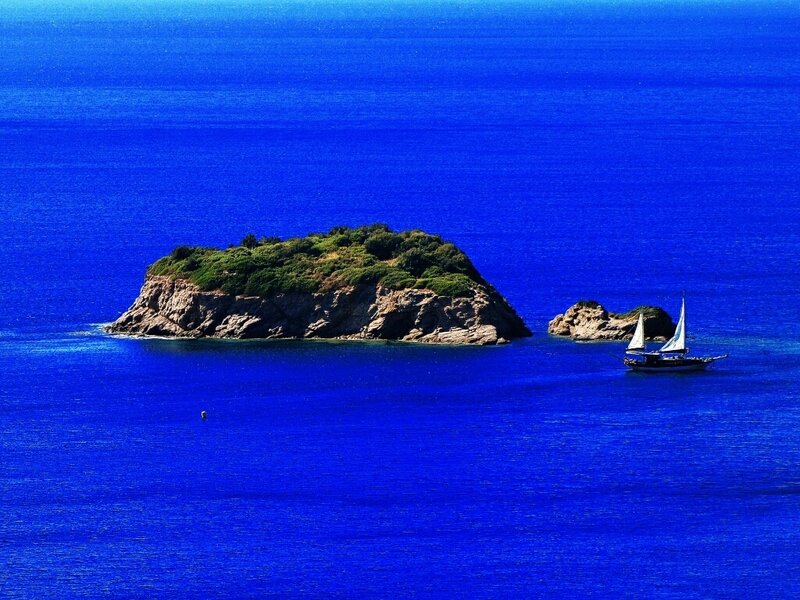 Sailboat near rocky island