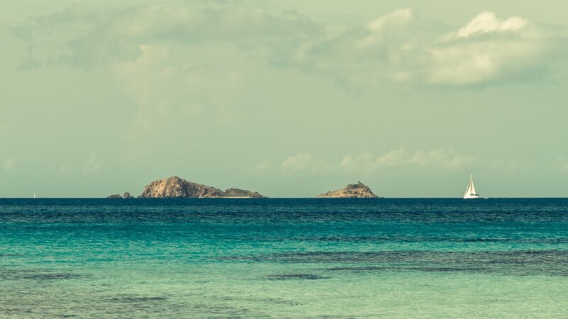 Sailboat Near Rocky Islands — Blue
