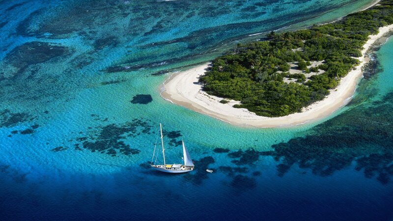 sailboat near tropical island