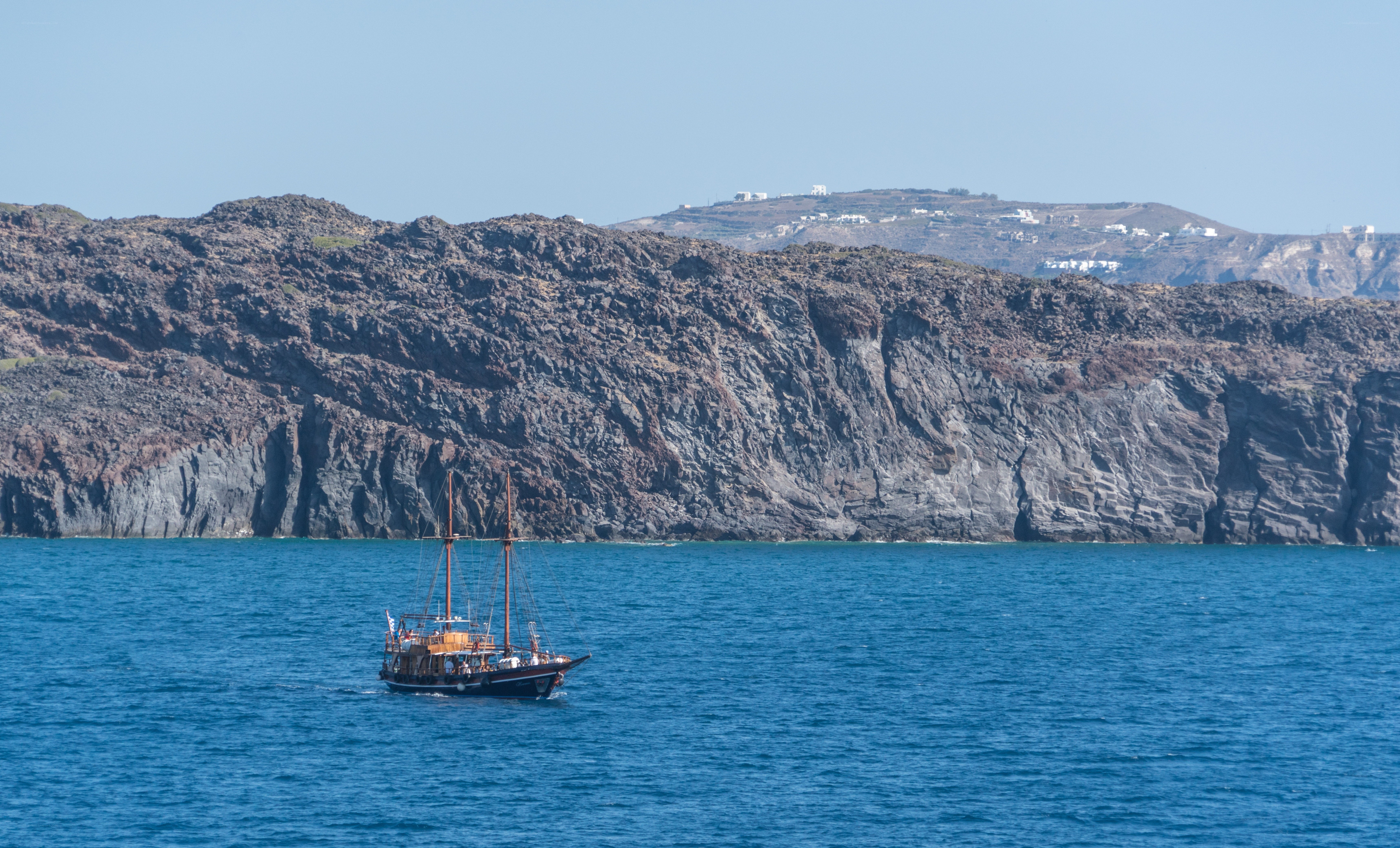 Sailboat near volcanic cliffs