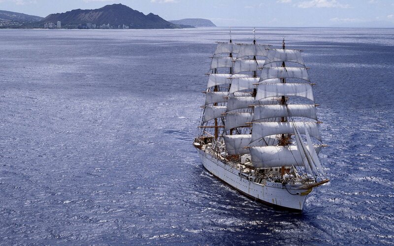 sailboat near volcanic island