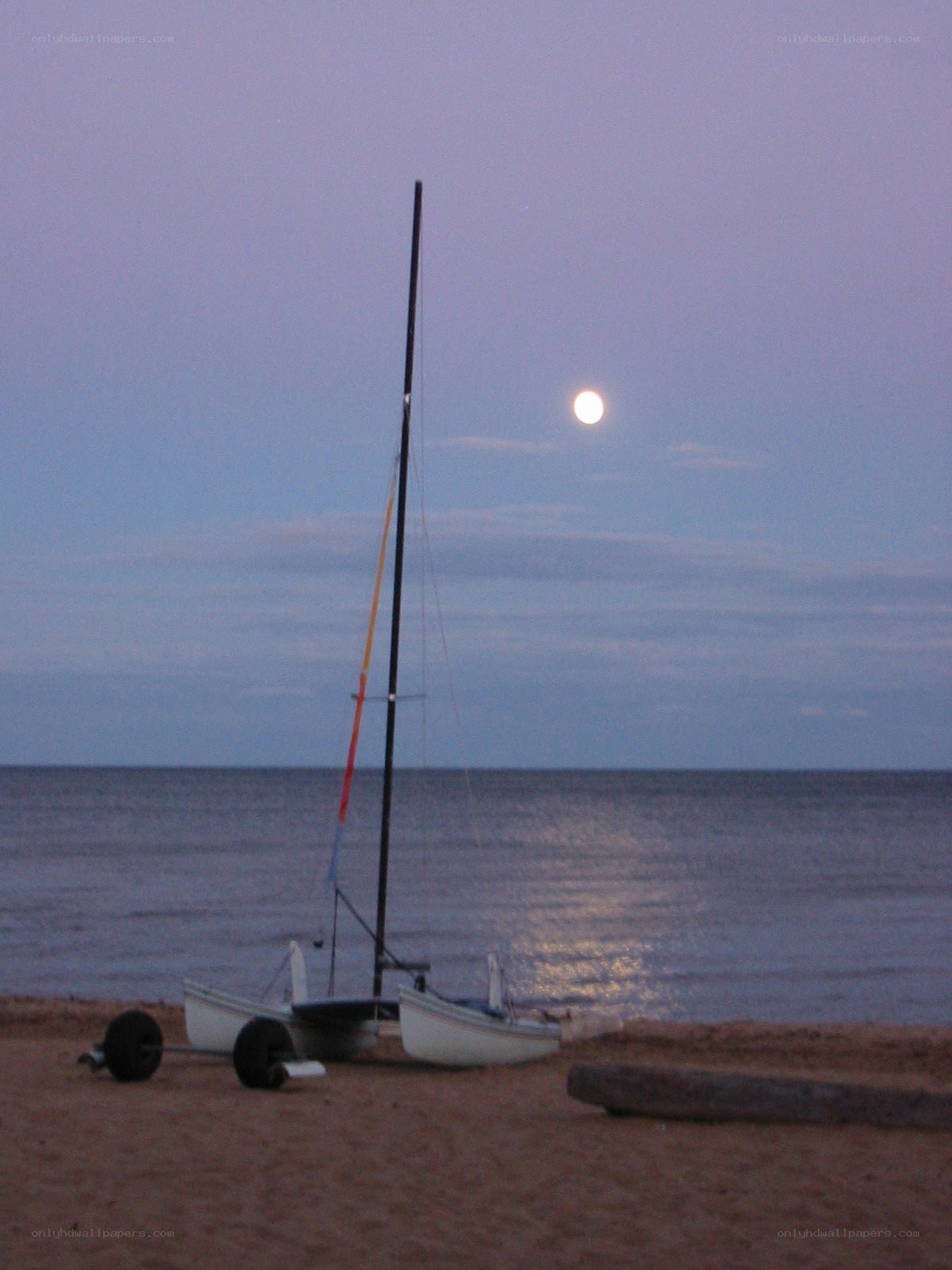 Sailboat on beach at moonrise