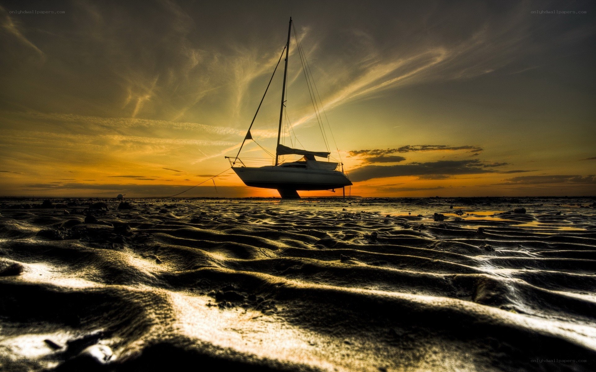 sailboat on beach at sunset