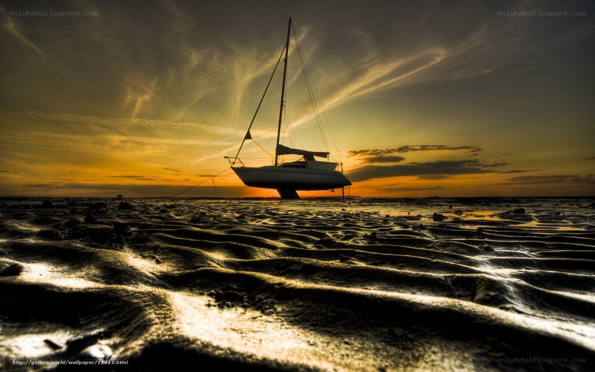 sailboat on beach at sunset