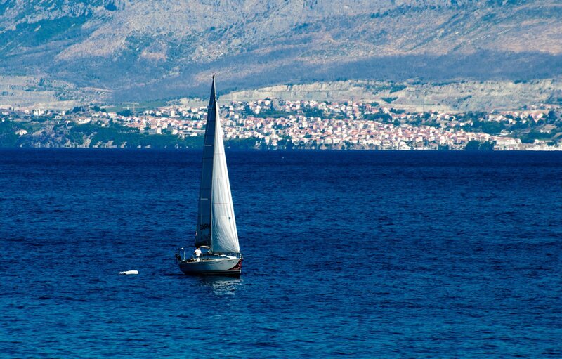Sailboat on Blue Water — Serene, Afternoon, Photograph, Mountain, Town