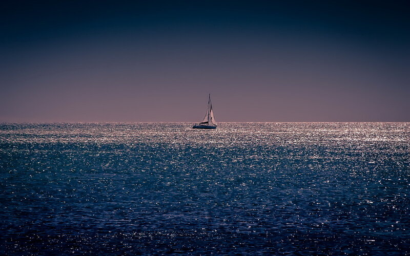 Sailboat on calm sea at dusk