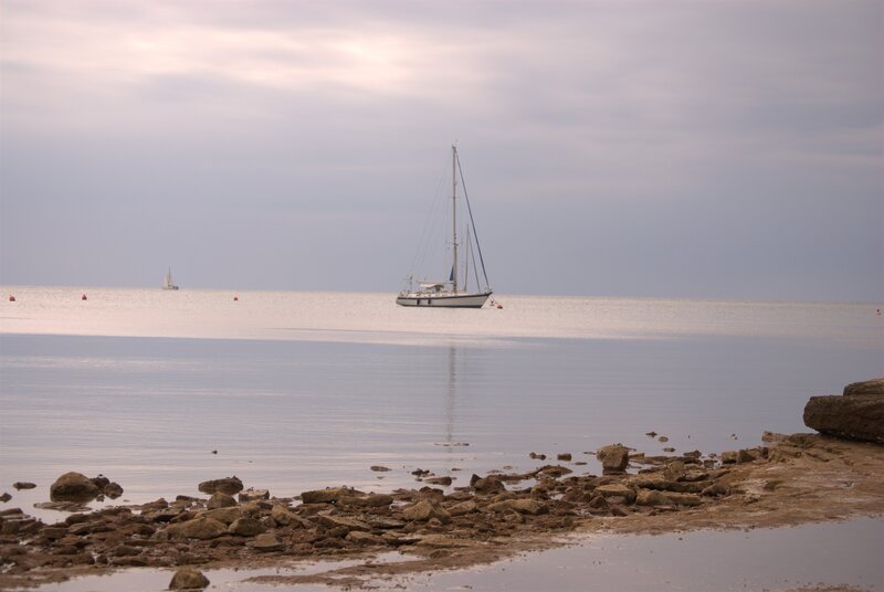 Sailboat on calm sea at low tide