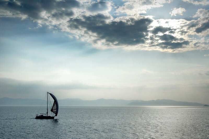 Sailboat on calm sea at sunset