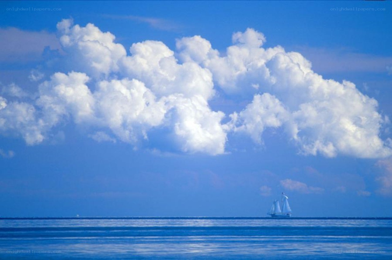 Sailboat on calm sea under clouds