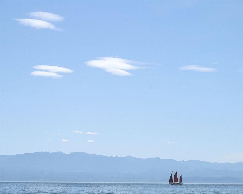 Sailboat on calm sea with mountains