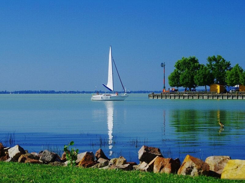 Sailboat on Calm Water — Blue, Serene, Afternoon, Photograph, Dock, Trees