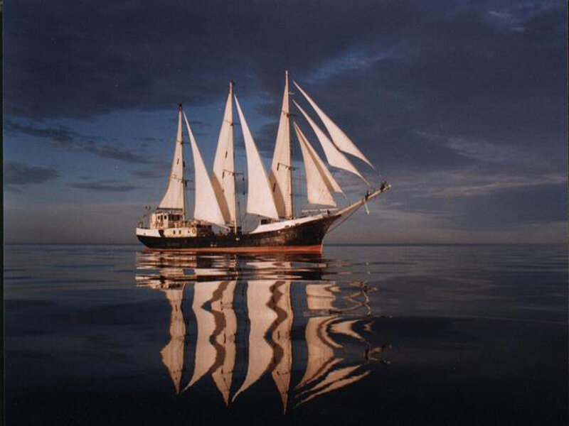 Sailboat on Calm Water — Blue, Serene, Sunset, Photograph, Sails