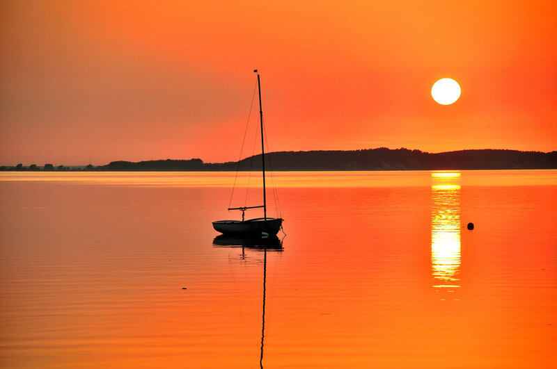 Sailboat on Calm Water — Orange, Serene, Sunset, Photograph, Sun, Land