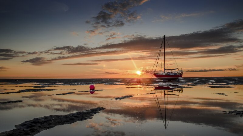 Sailboat on Tidal Flats — Orange, Serene, Sunset