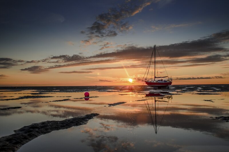 Sailboat on Tidal Flats — Orange, Serene