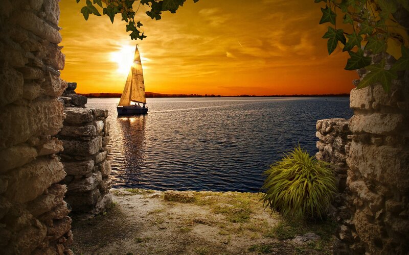 Sailboat on Water — Orange, Serene, Sunset, Photograph, Stone Wall