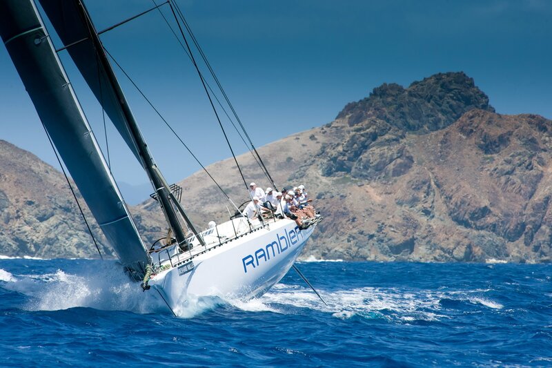 Sailboat racing near rocky coast