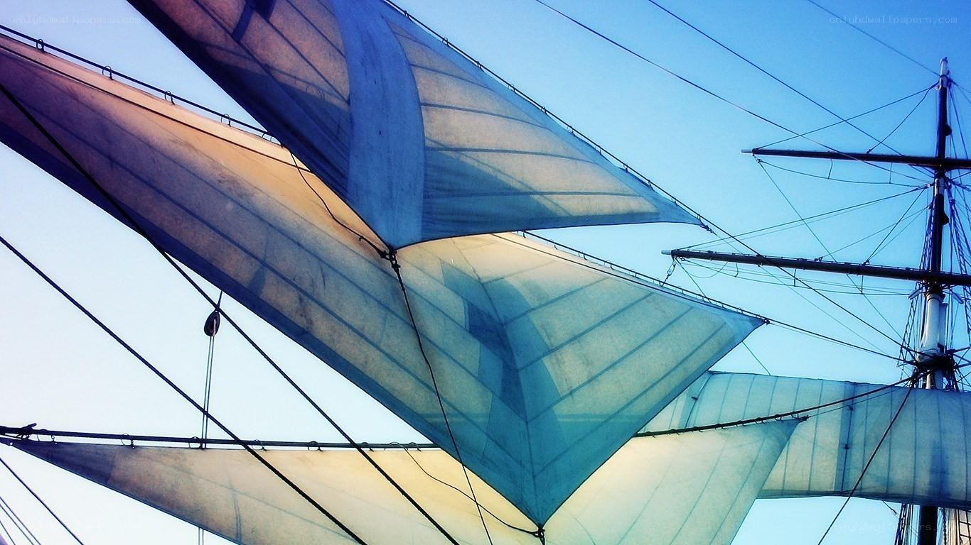 sailboat sails against blue sky