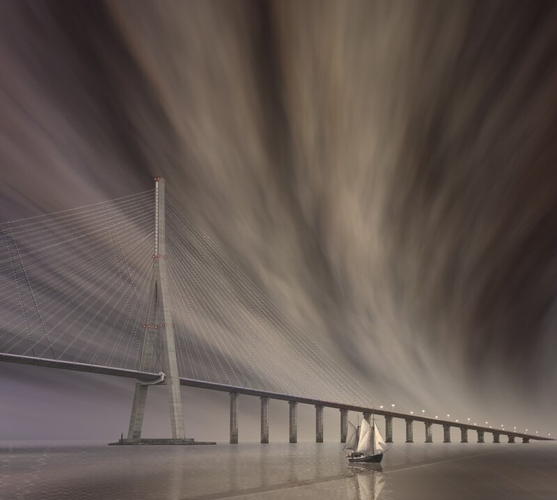 Sailboat under a modern bridge