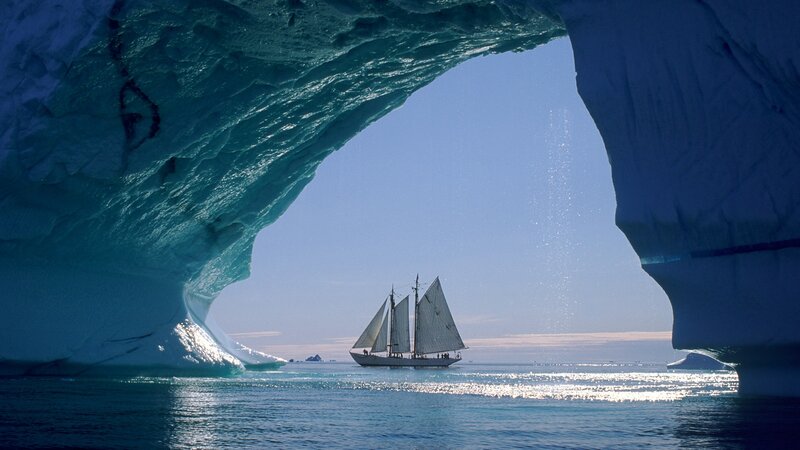 Sailboat under Iceberg Arch — Blue, Serene, Afternoon, Photograph, Ocean