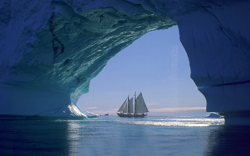 Sailboat under Iceberg Arch — Blue, Serene, Afternoon