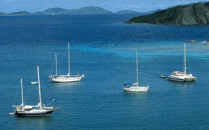 Sailboats anchored in a tropical bay