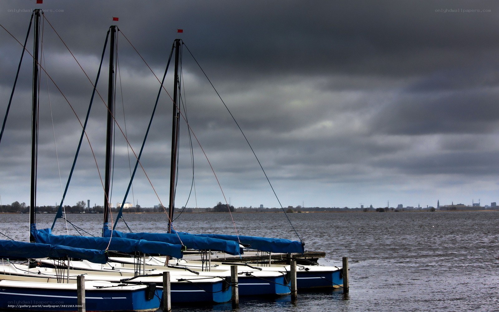 Sailboats at a dock under stormy sky
