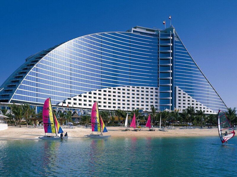 Sailboats at beach with modern hotel