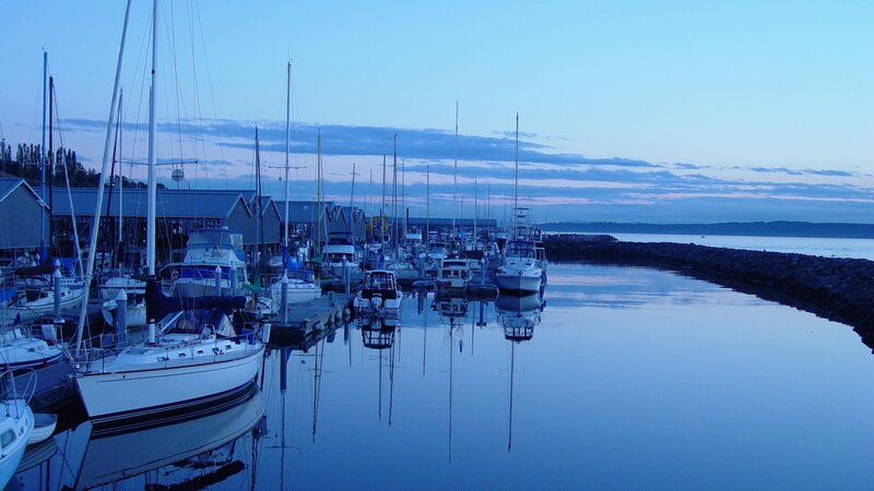 Sailboats at dusk in a calm harbor