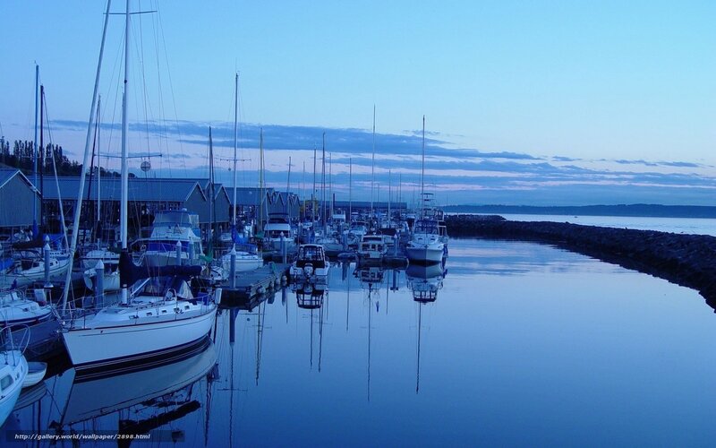 Sailboats at dusk in a calm harbor