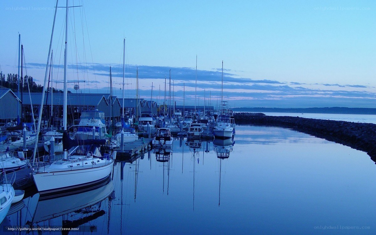 Sailboats at dusk in a calm harbor
