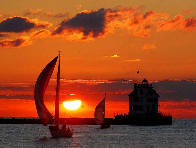 Sailboats at sunset by lighthouse