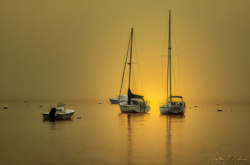 Sailboats at sunset on calm water