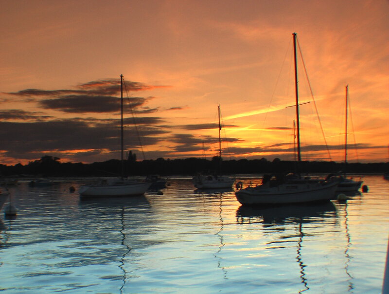 Sailboats at sunset on calm water