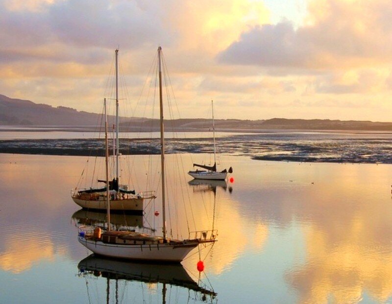 Sailboats at sunset on calm water