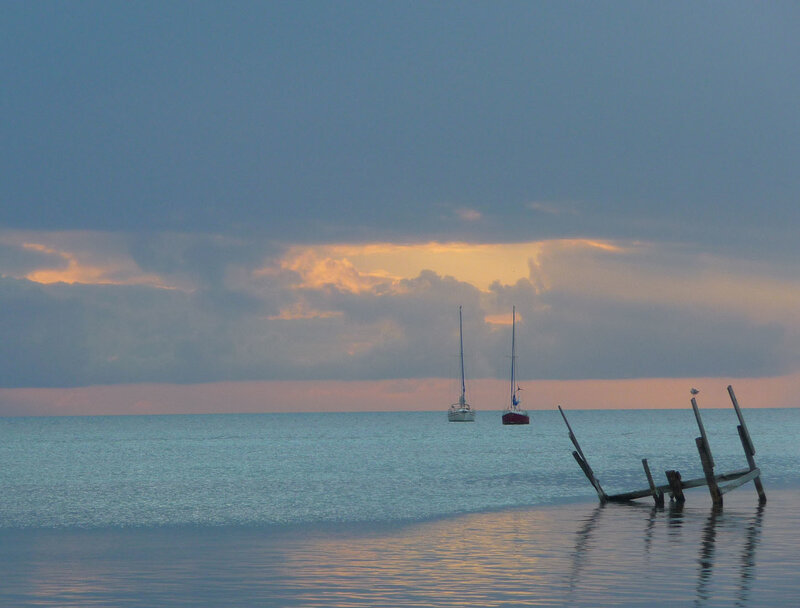 Sailboats at sunset on calm water