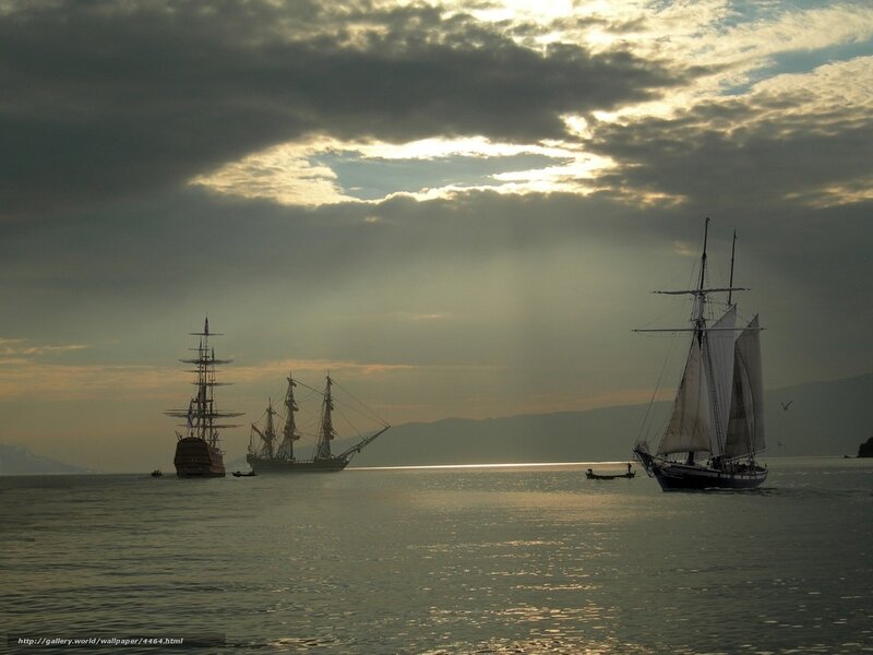 Sailboats at sunset on calm water