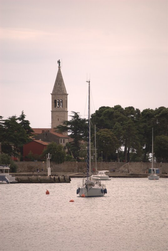 Sailboats in a harbor with a church tower
