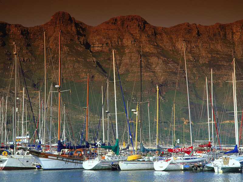 Sailboats in harbor with mountains