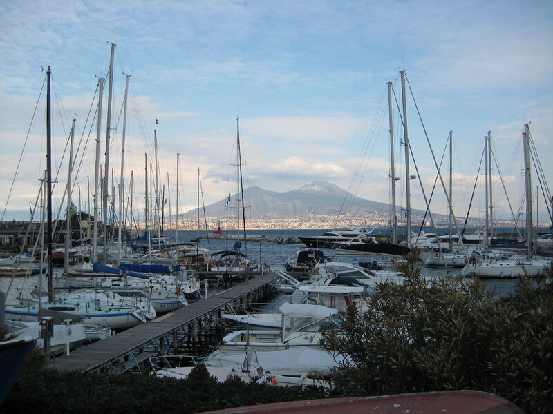 Sailboats in harbor with volcano