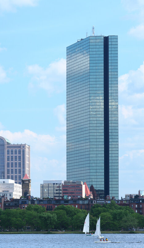 Sailboats near a glass skyscraper