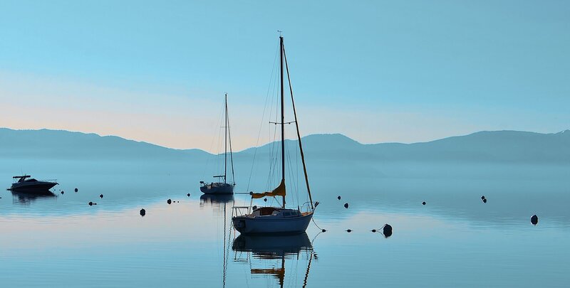 Sailboats on a calm lake at dawn
