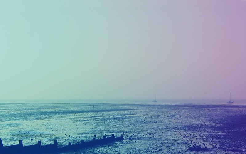 sailboats on a misty coast