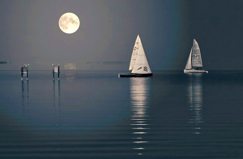 Sailboats under a full moon